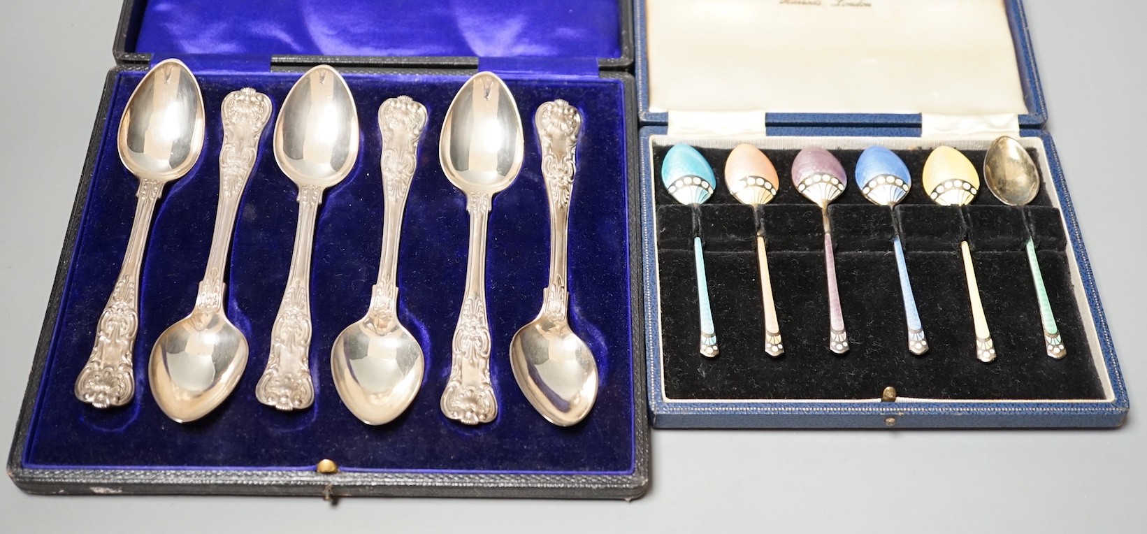 A cased set of six 1960's silver and polychrome enamelled coffee spoons, Turner & Simpson, 97mm and a case set of six William IV silver Kings pattern teaspoons, London, 1835, 14.3cm.